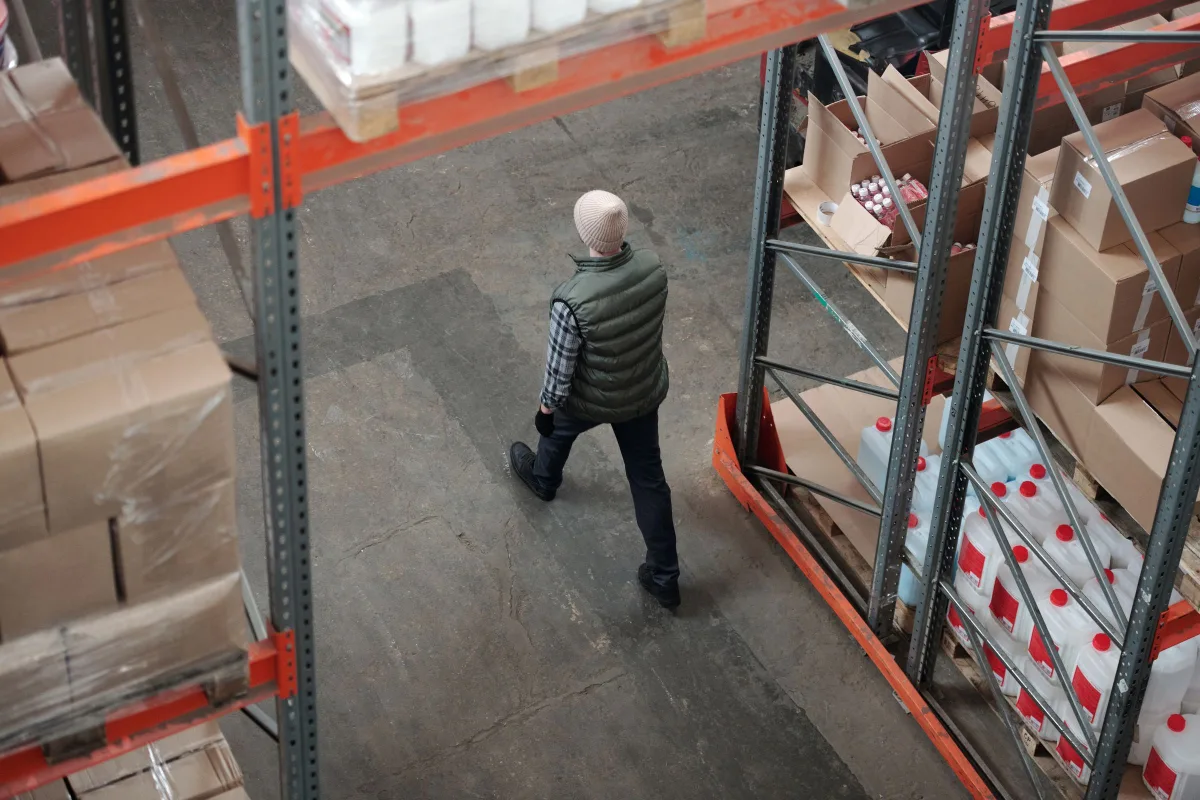 Pasillo de un almacén visto desde arriba, con las estanterías llenas de cajas.